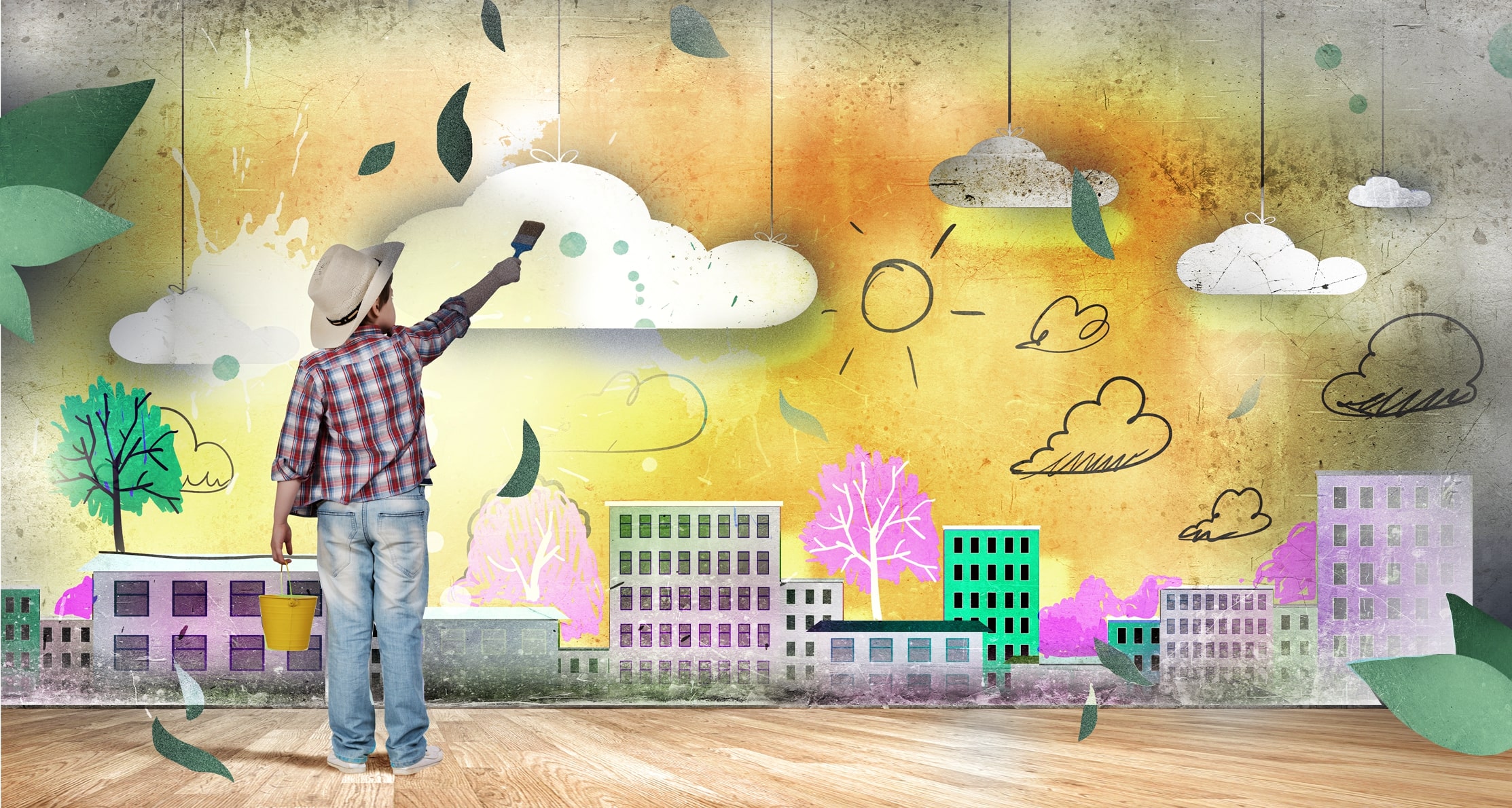 Ein junge zeichnet mit einem Pinsel auf einer Wand seine nachhaltige Vorstellung der Zukunft