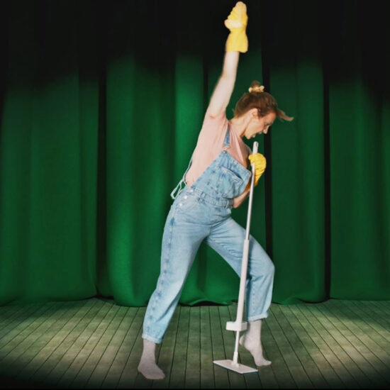 Eine Frau tanzt mit einem Wischmop