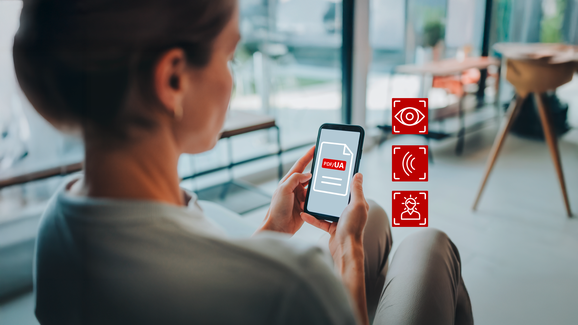 Das Bild zeigt eine Person, die auf einem Smartphone ein PDF/UA-Symbol betrachtet. Daneben stehen drei rote Icons für Seh-, Hör- und kognitive Barrierefreiheit.